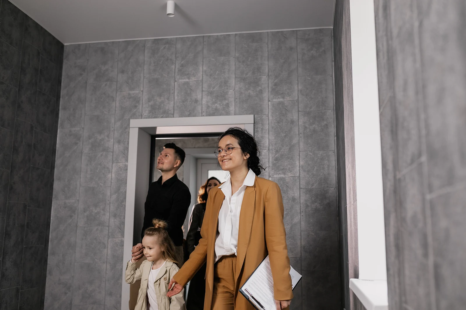 A family touring a home with a real estate professional